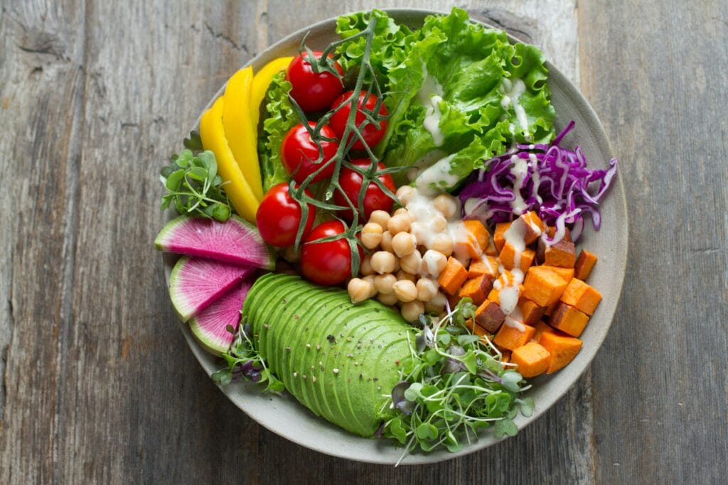 A bowl full of colorful fruits and vegetables representing a balanced diet and fitness lifestyle.