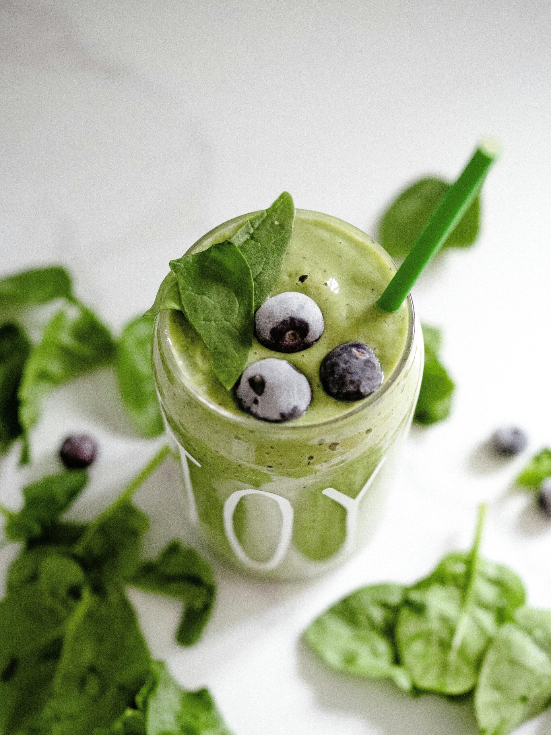 A vibrant green smoothie made with spinach and topped with fresh blueberries, a refreshing and nutritious option among healthy recipes.