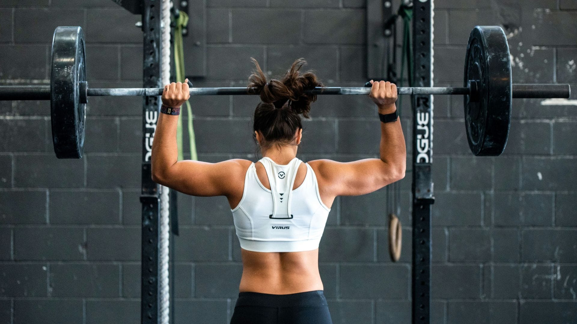 Strong woman lifting weights as part of an advanced strength training for women