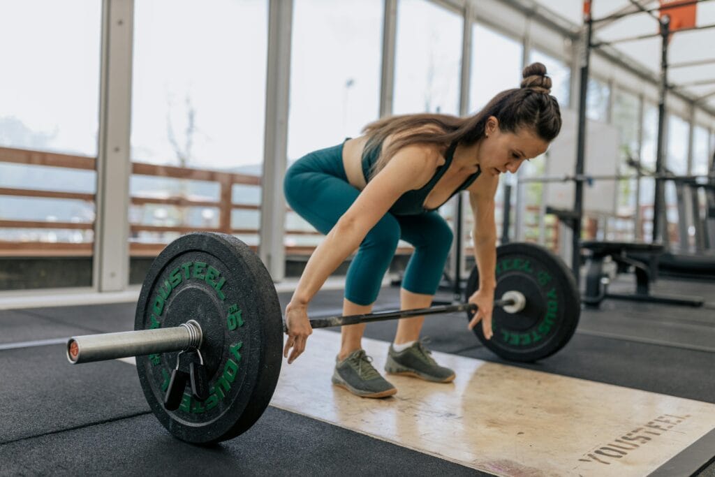 Woman performing a barbell lift as part of strength training for women