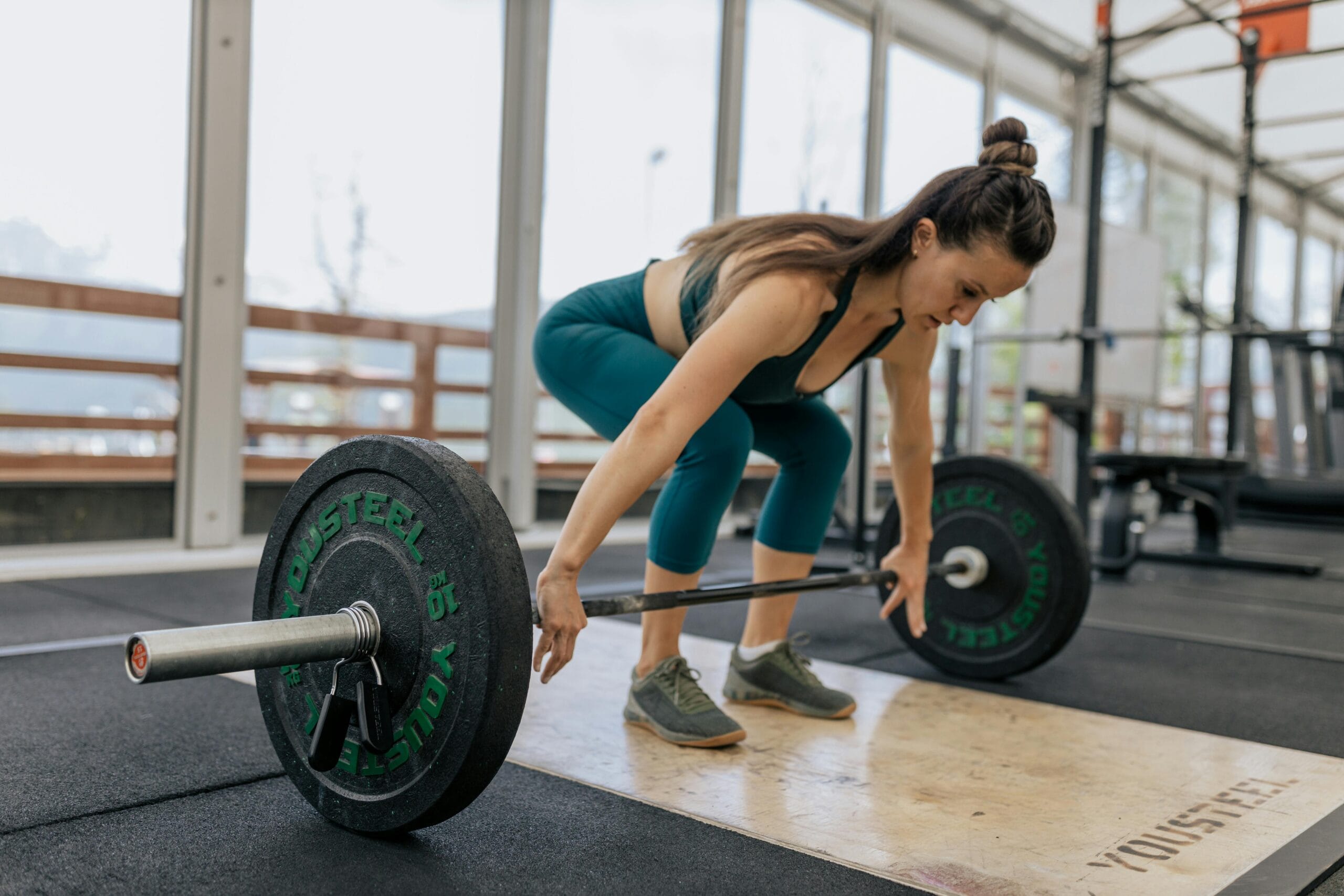 Woman performing a barbell lift as part of strength training for women