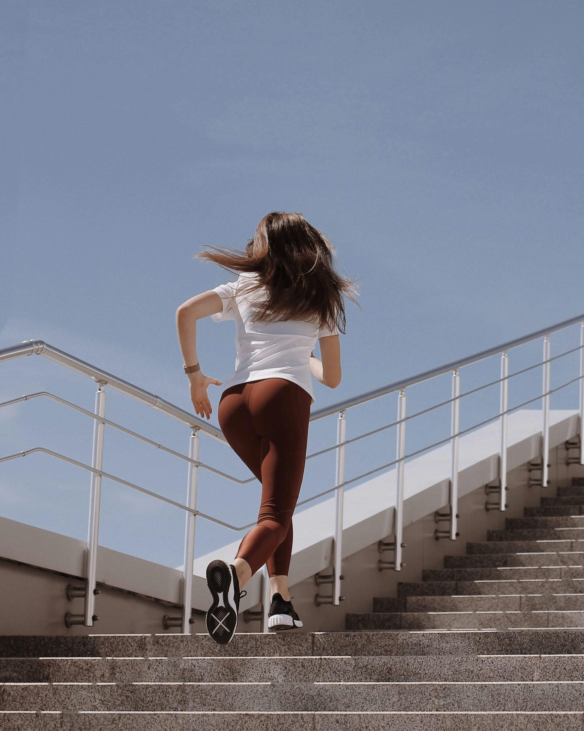 Woman running up stairs to improve endurance and support strength training for women