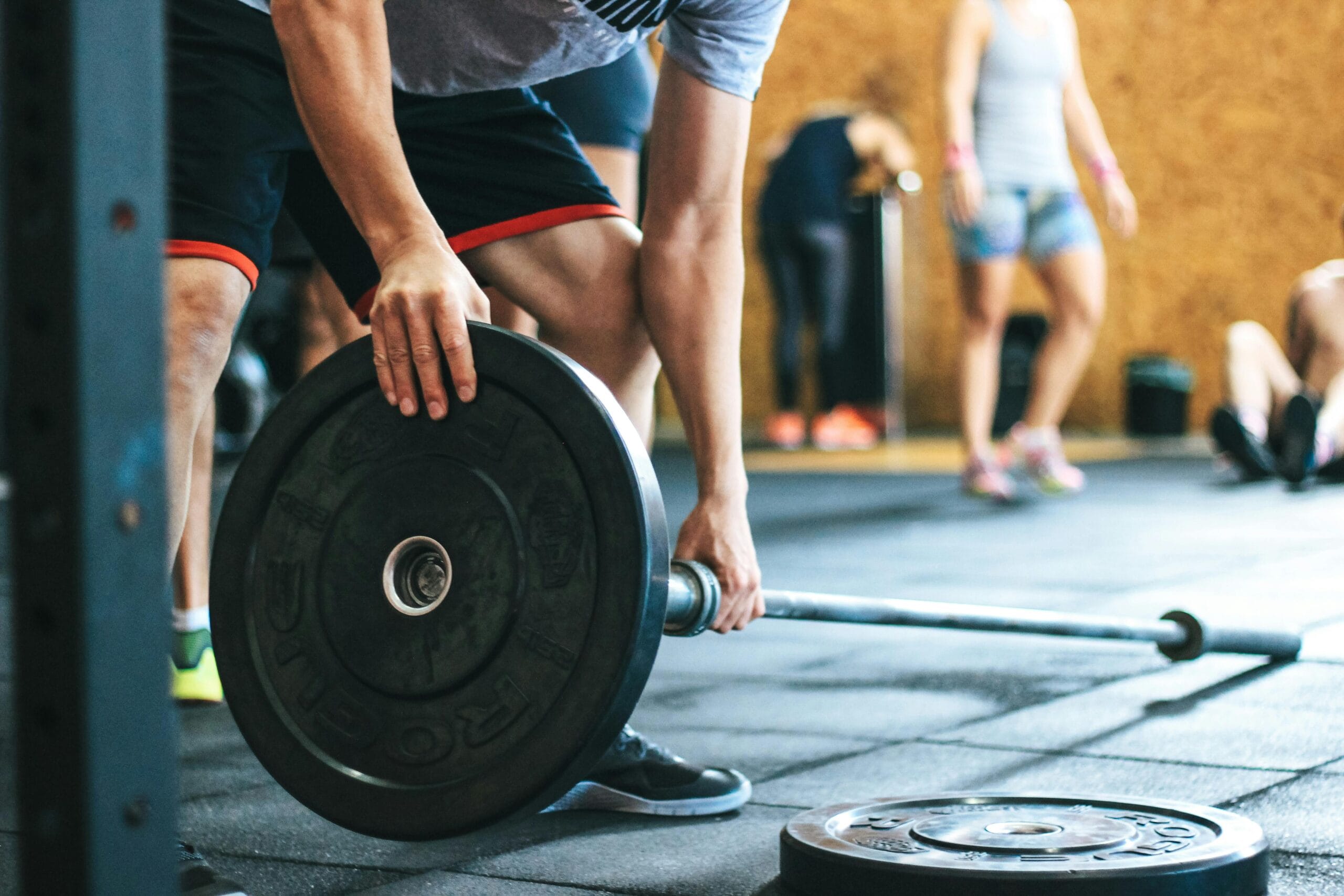 man adjusting weights on a barbell before strength training